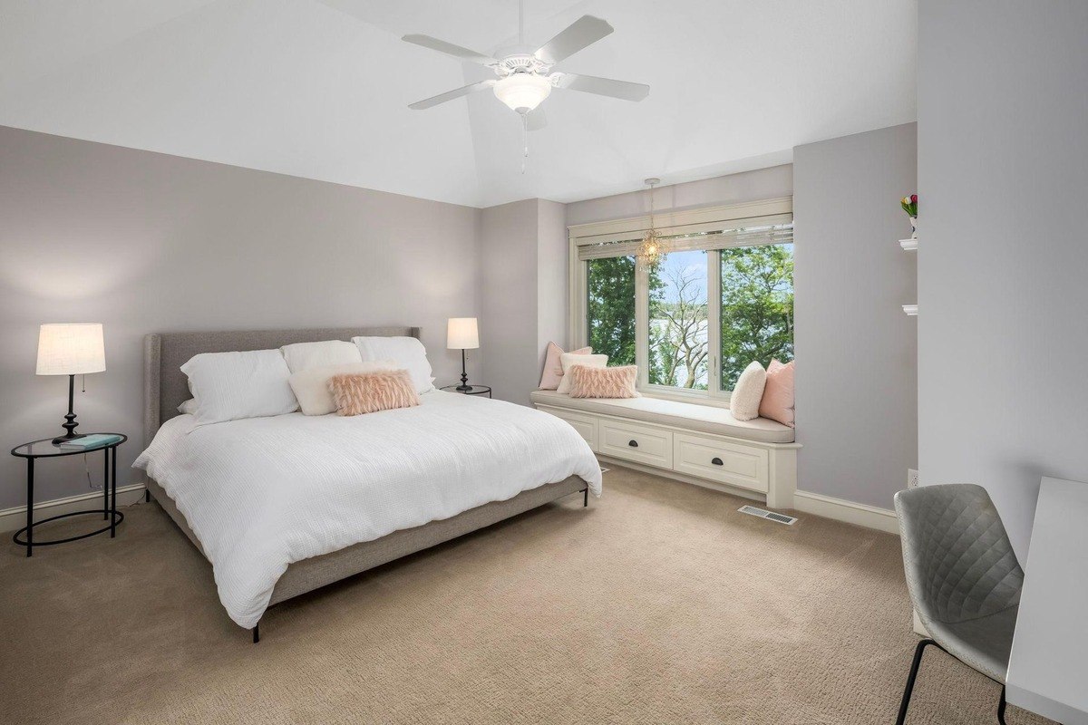 Cozy bedroom with a window seat and lake view.