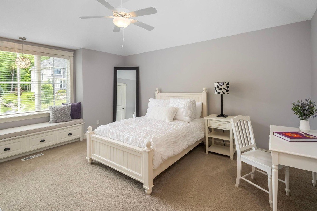 Bright bedroom featuring neutral tones and built-in window bench.