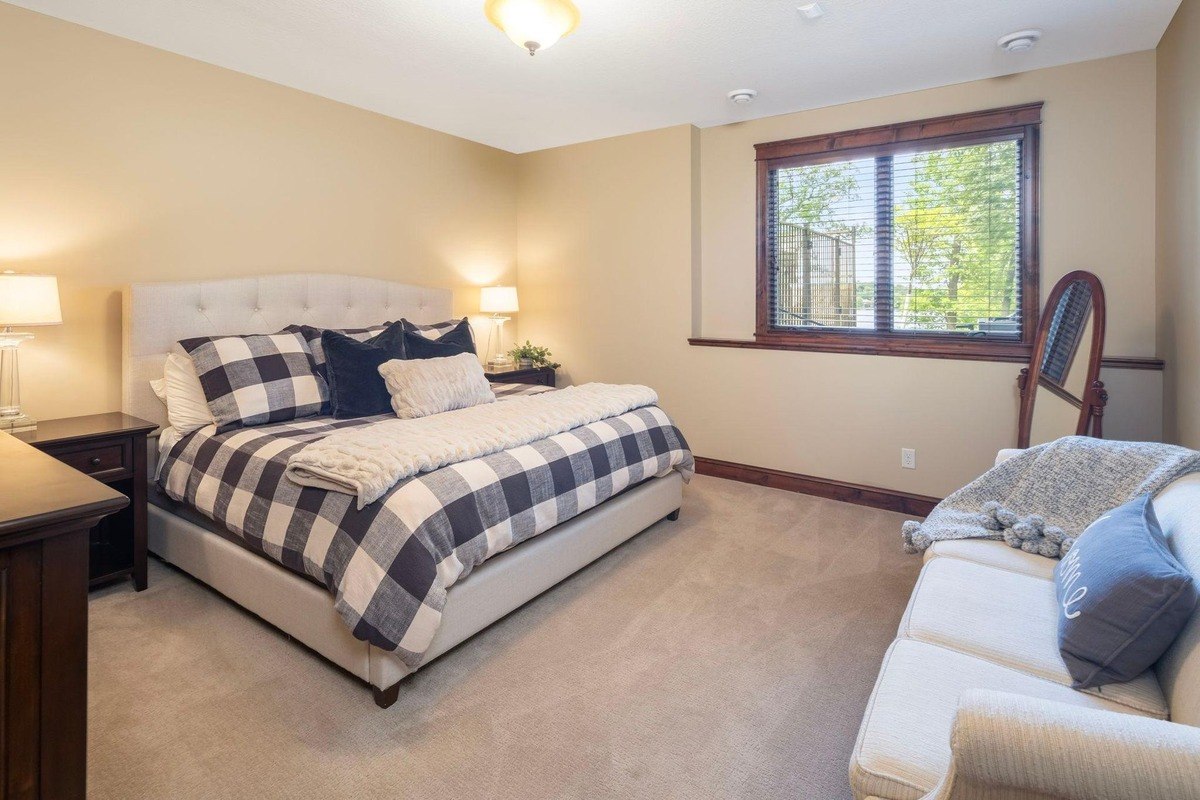 Lower-level bedroom with warm tones and natural wood trim.