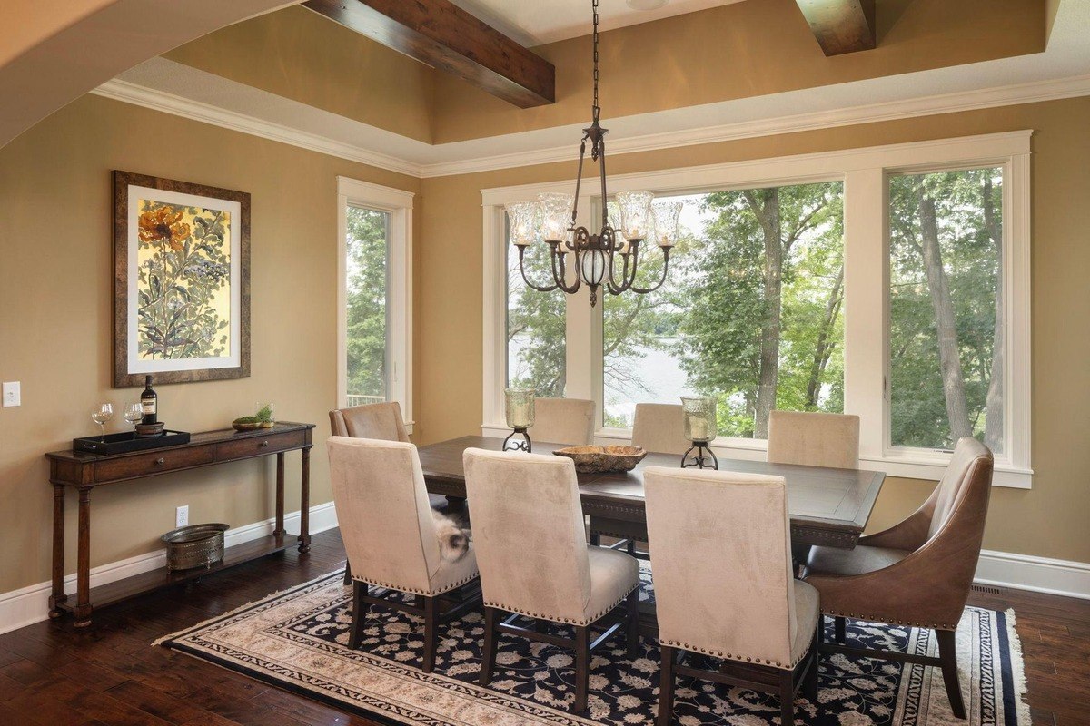 Dining area with large windows offering scenic outdoor views and a chandelier above.