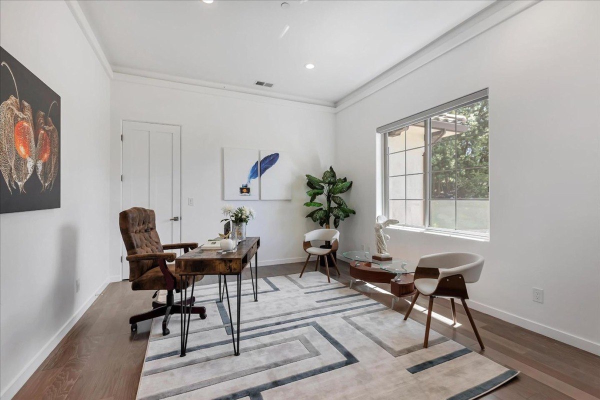 Home office with modern furniture, a large desk, and ample natural light.