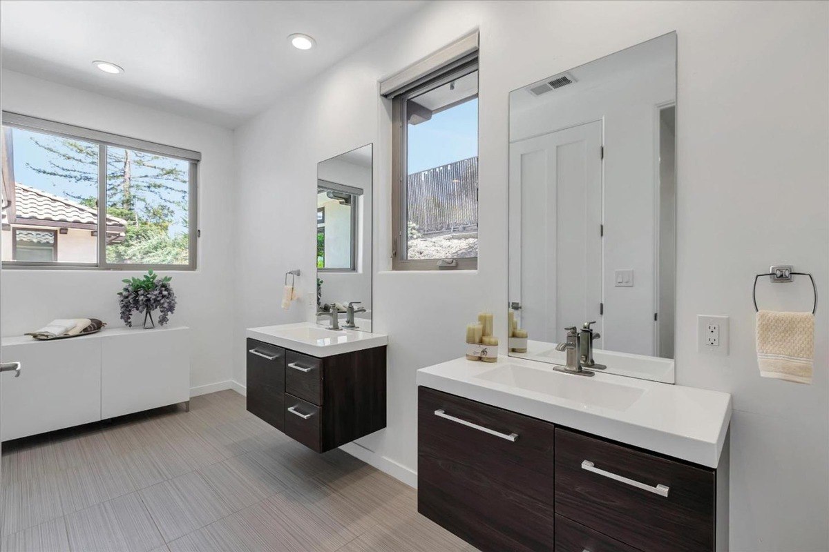 Bathroom with dual sinks A bathroom with double floating sinks and a large window.