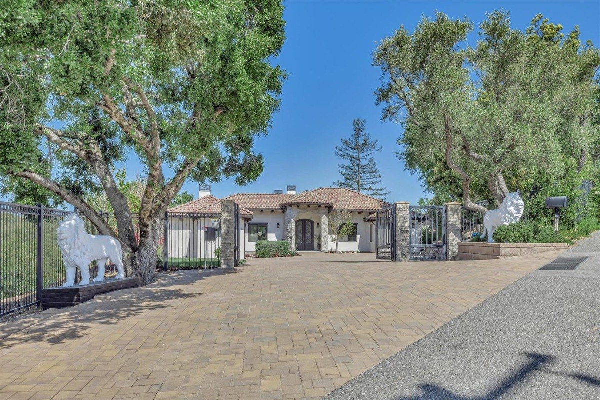 Front entrance with a gated driveway and stone details.