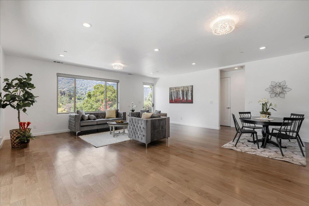 Spacious living area with large windows providing a view of the hills.