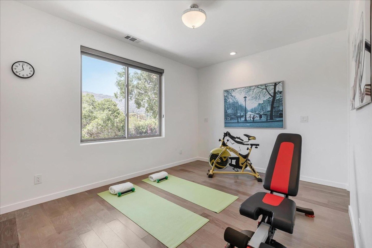 Home gym with large windows and exercise equipment.