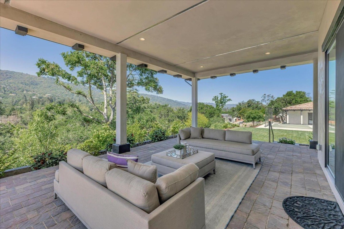 Covered outdoor lounge area with comfortable seating and scenic surroundings.