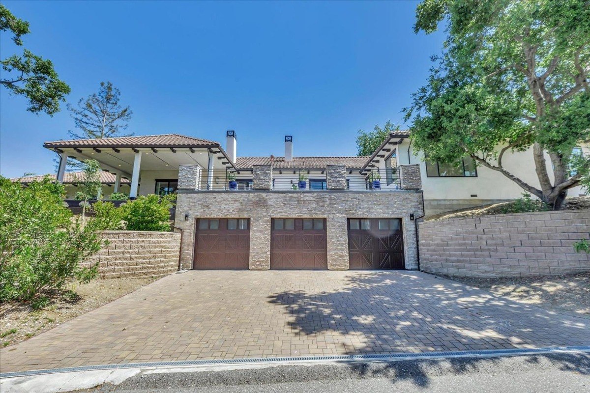 Front view of the home showcasing a three-car garage and modern architecture.