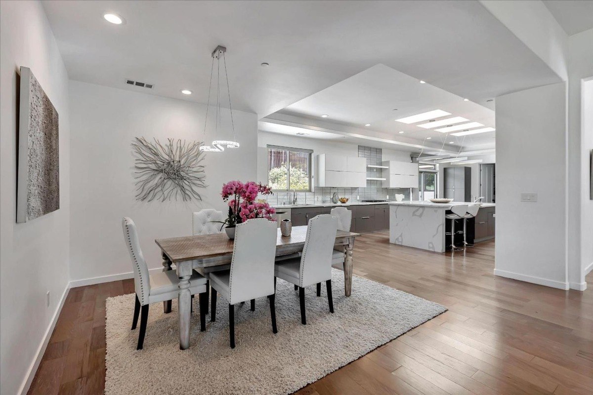 Open-concept dining area adjacent to the kitchen, with hardwood floors and modern lighting.