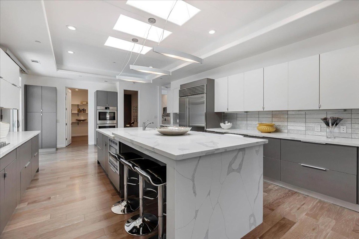 Kitchen with a large island, marble countertops, and modern cabinetry.