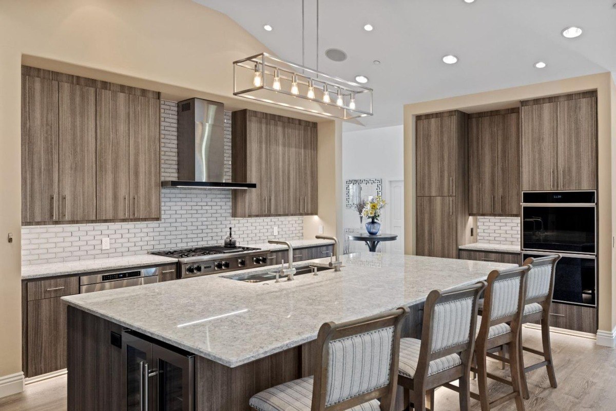 Modern kitchen featuring a spacious island with seating, sleek cabinetry, and high-end appliances, creating a stylish and functional culinary space.