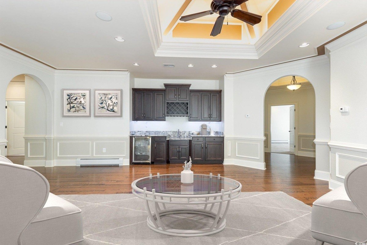 Room has hardwood floors, a wet bar, and a coffered ceiling.