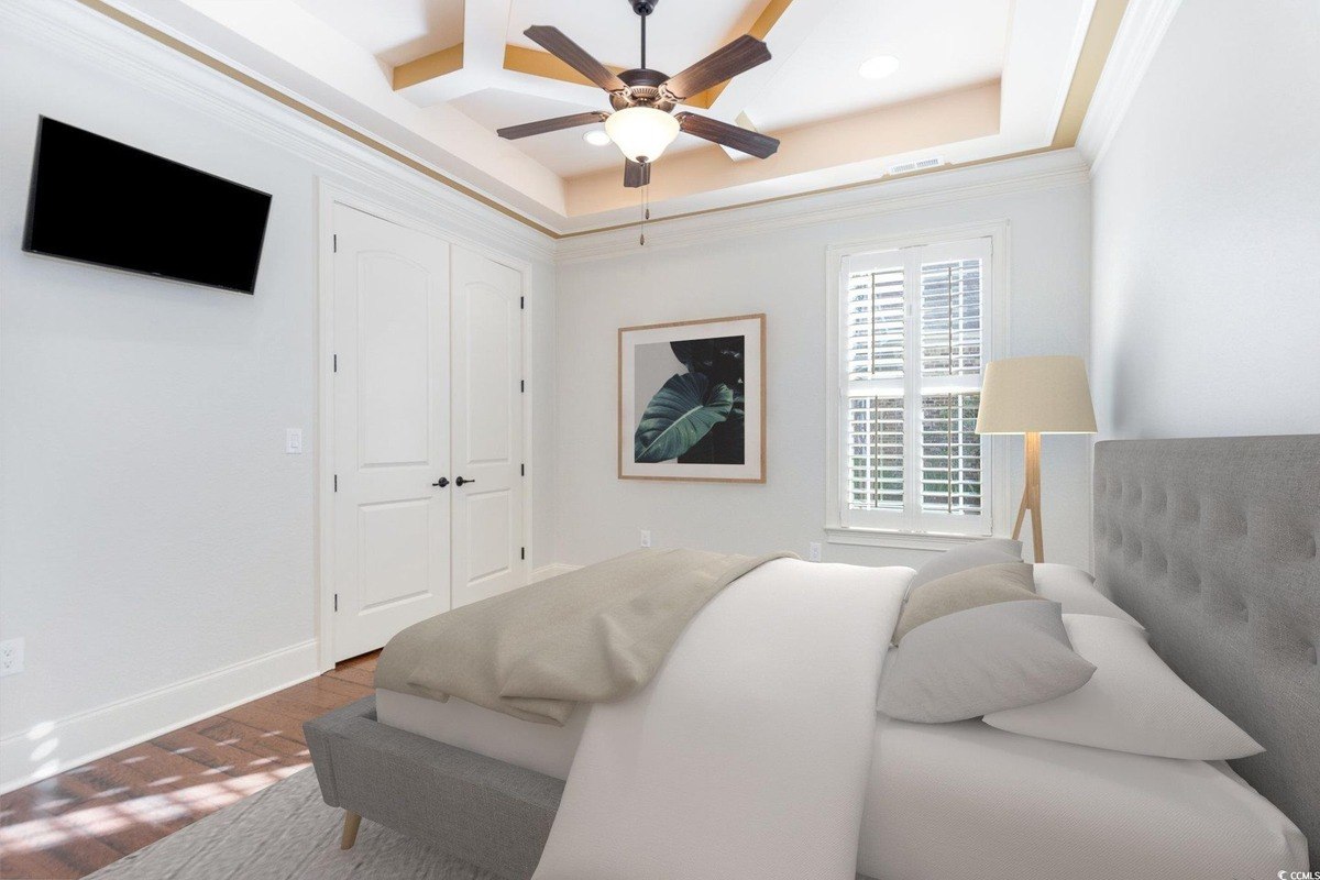 Bedroom has hardwood floors, a bed, and a ceiling fan.