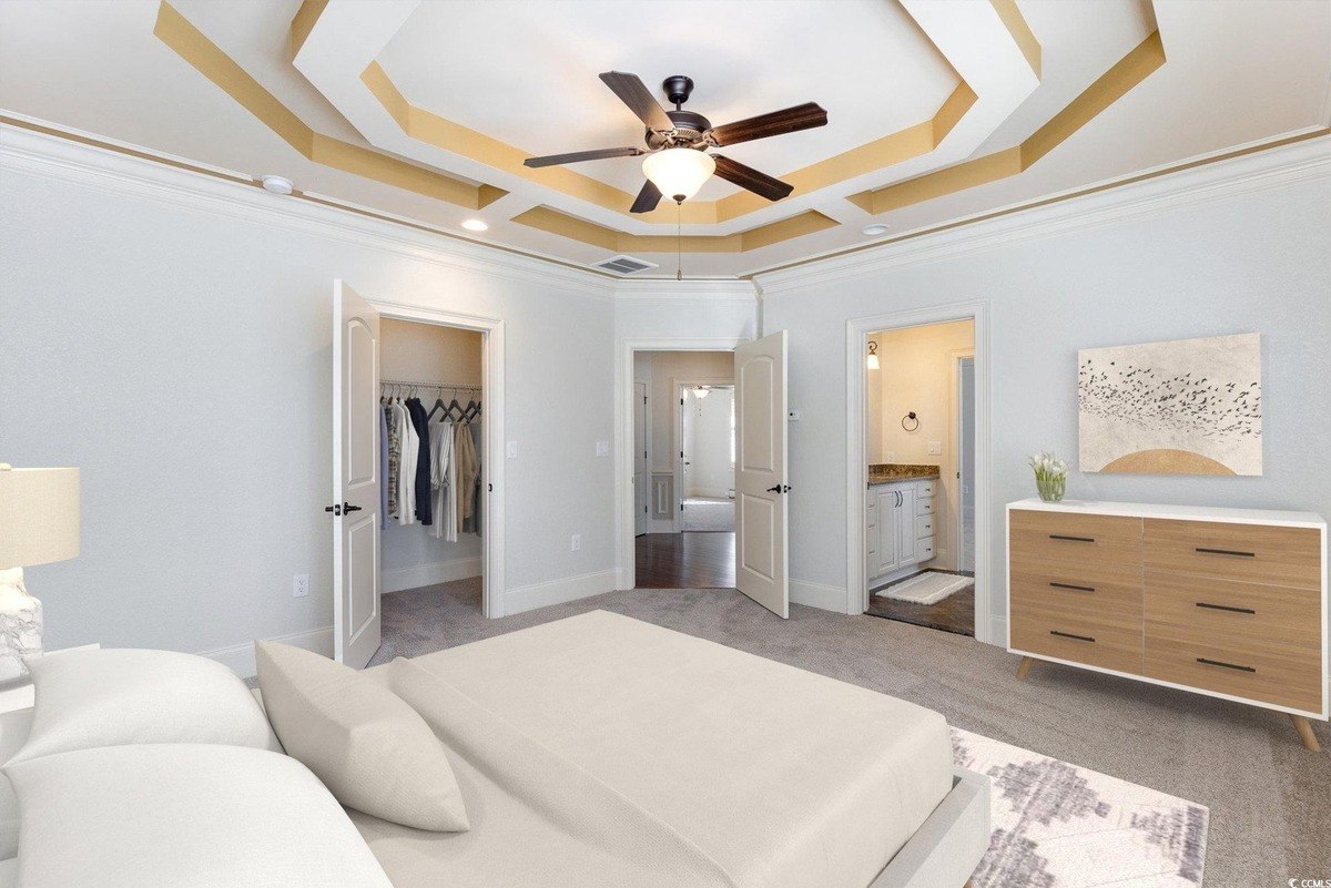 Master bedroom has carpeting, a bed, and a ceiling fan with a unique design.