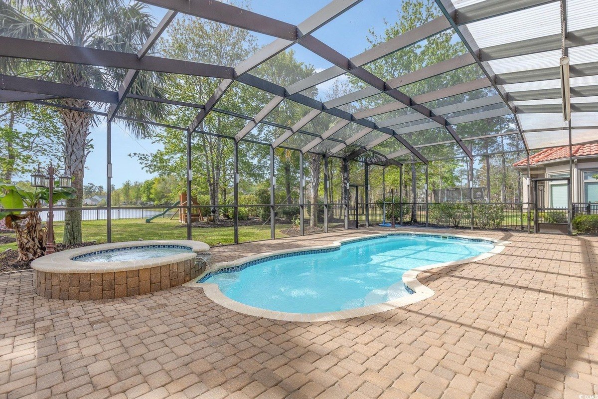 Pool and spa area is enclosed by a screened-in patio.