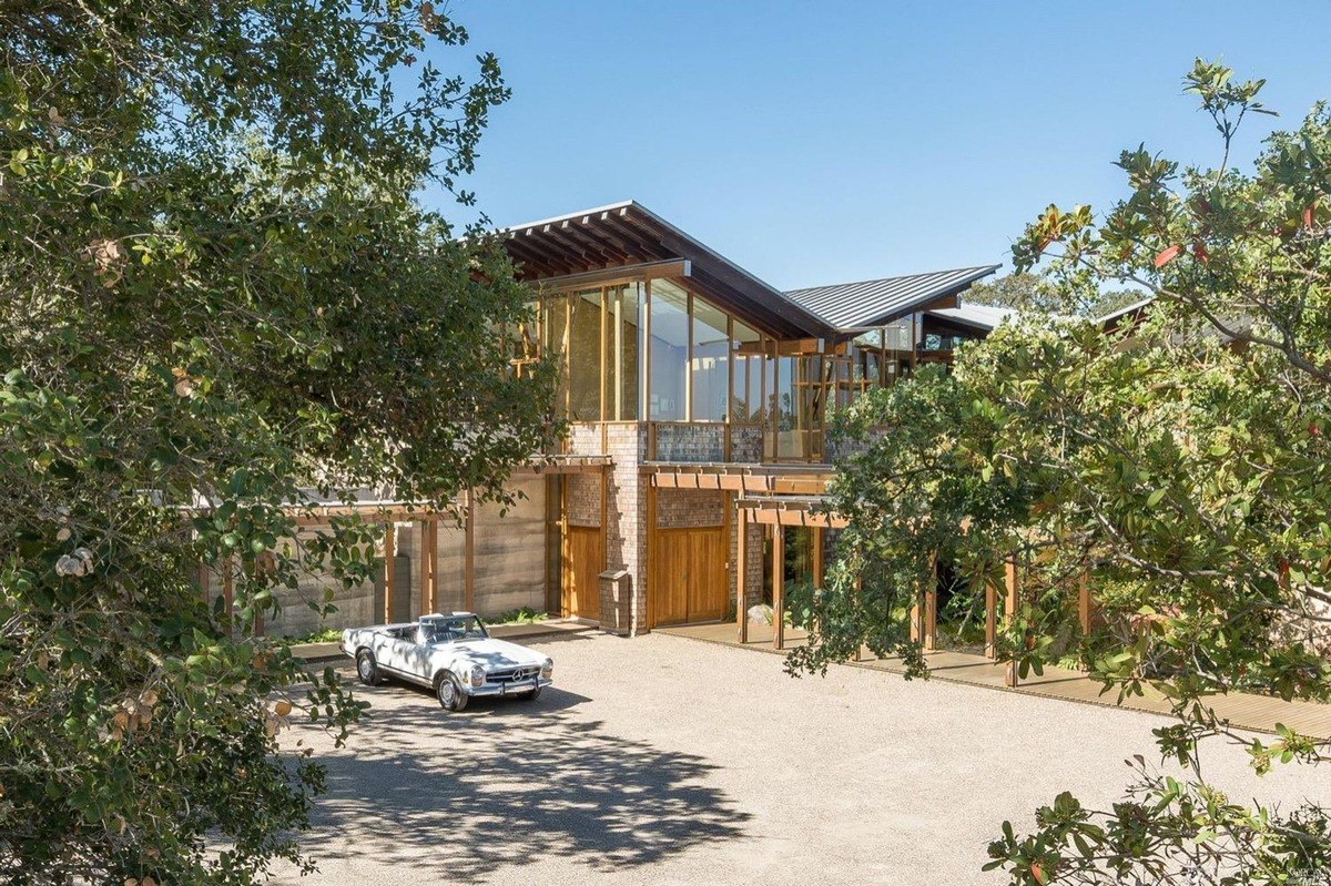 Courtyard view of a glass-walled contemporary home with natural wood accents.