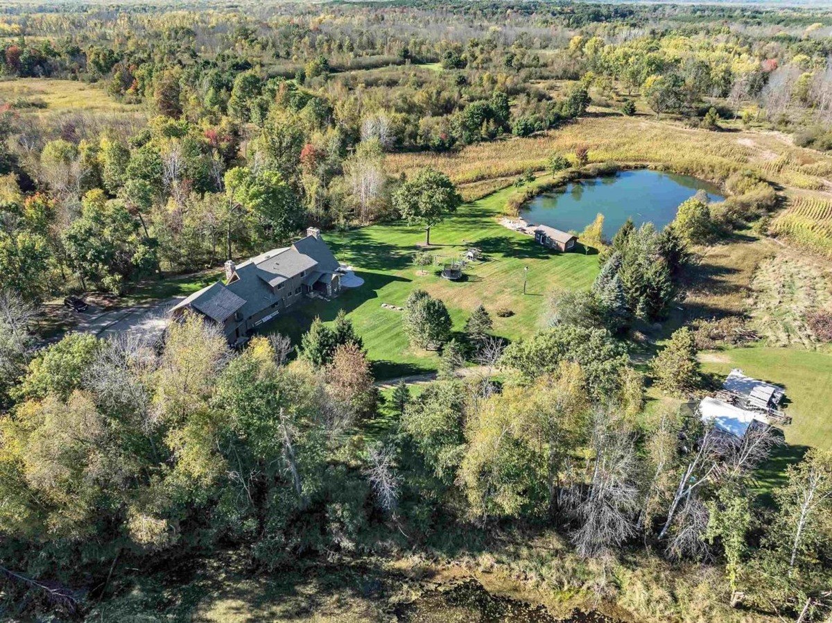 Aerial view shows a large property surrounded by lush greenery and