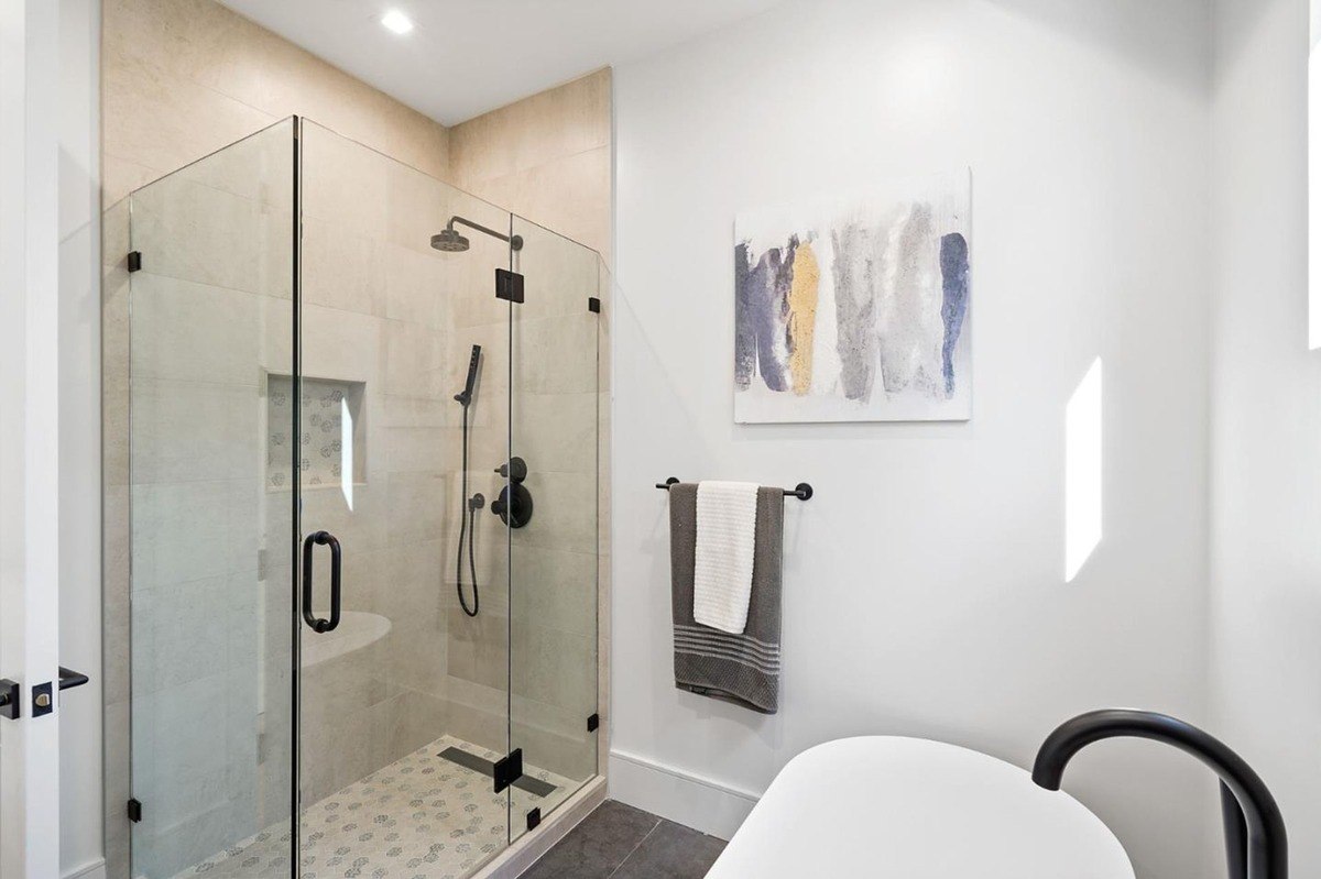 Glass shower and freestanding tub a bathroom featuring a glass-enclosed shower, freestanding tub, and textured wall accents.