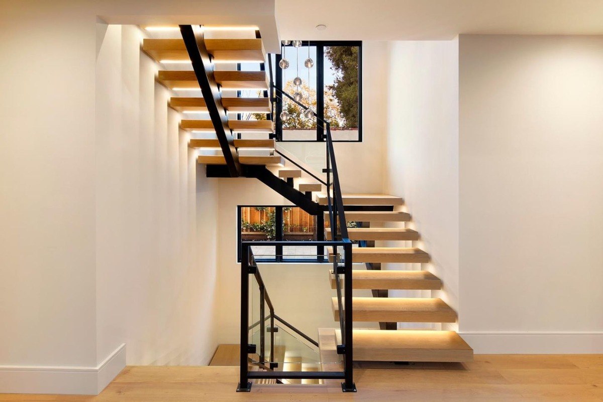 Modern floating staircase a sleek floating staircase with wooden steps, black railings, and glass panels.