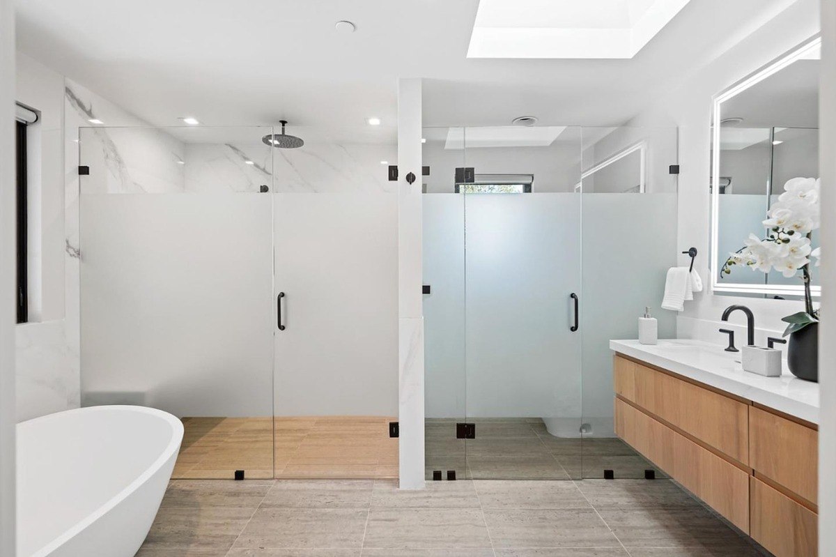 Bathroom with double shower a primary bathroom featuring a glass-enclosed double shower, a freestanding tub, and dual vanity.