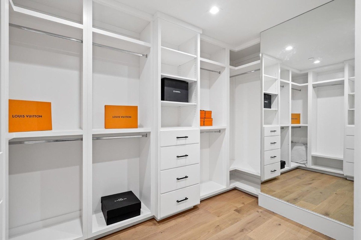 Walk-in closet with custom shelving a bright walk-in closet with built-in shelves, drawers, and a full-length mirror.