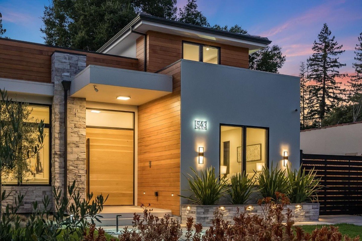 Front entry close-up close-up of the front entrance featuring a sleek wooden door, stone details, and modern lighting.