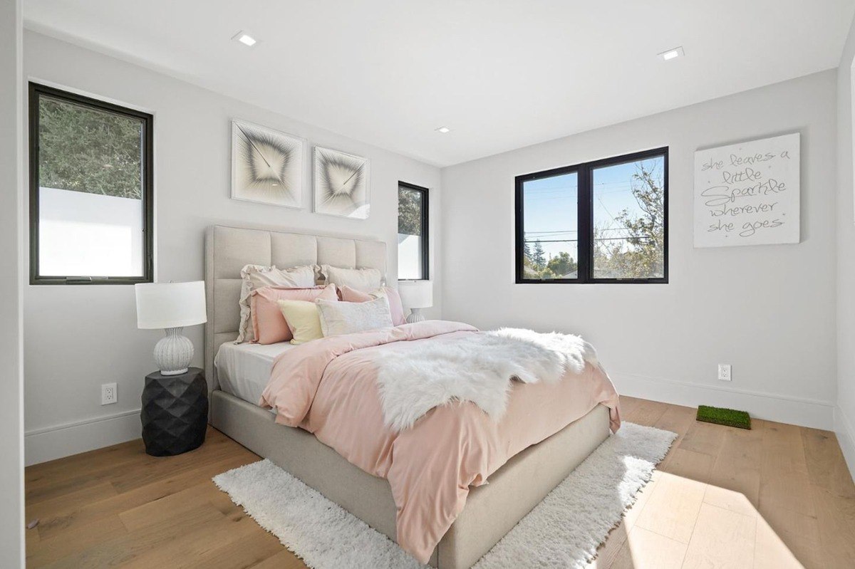 Guest bedroom with soft decor: a cozy guest bedroom with a neutral-toned bed, soft pink accents, and large windows.