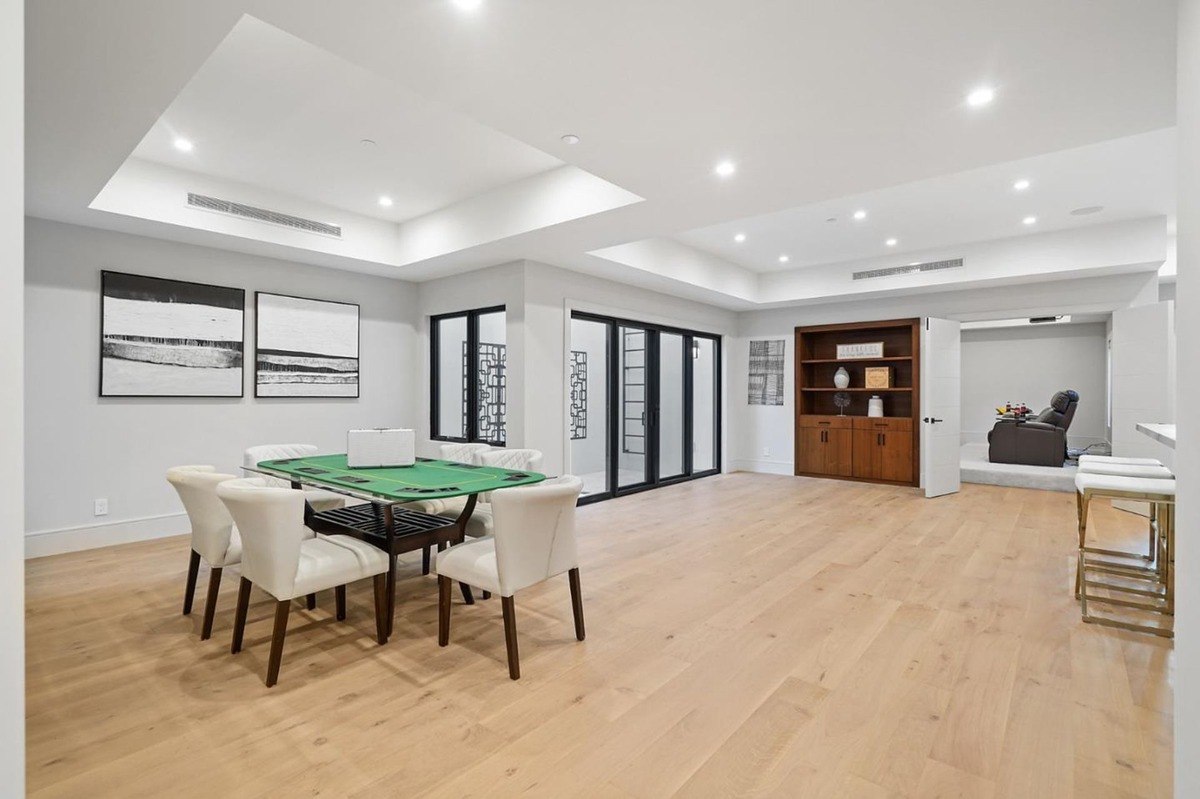 Dining/game room a spacious room with a card table, art on the walls, and an adjacent entertainment area.