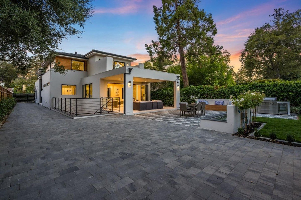 Backyard overview a backyard space with a dining table, outdoor kitchen, and paved pathways.