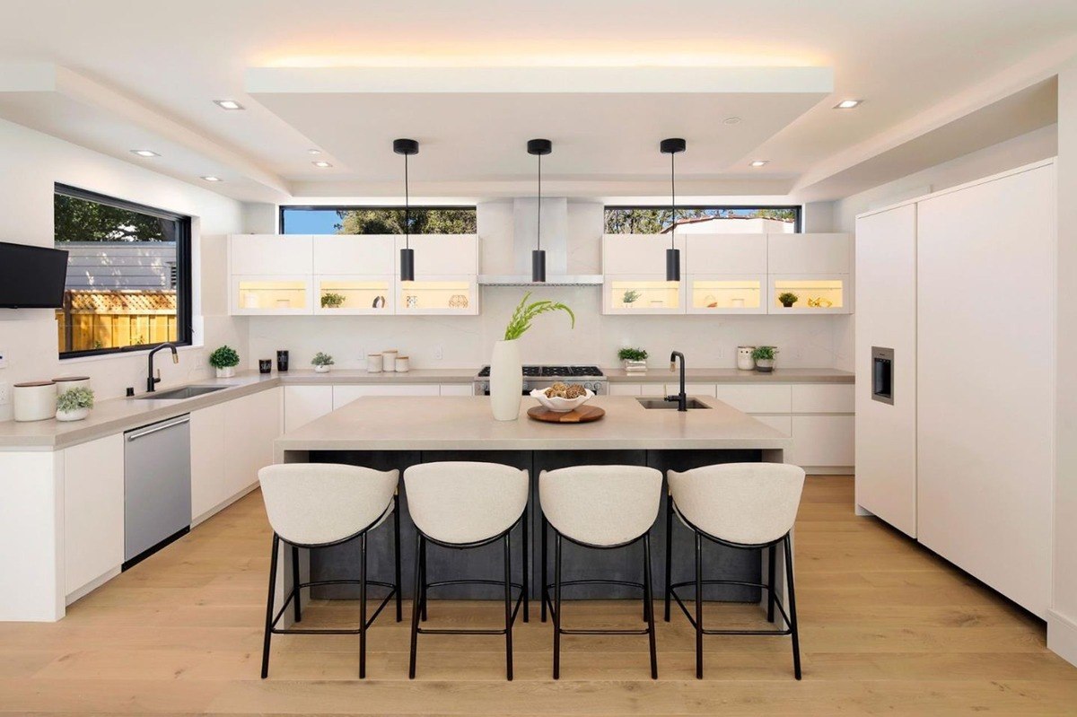 Sleek kitchen a modern kitchen with white cabinets, a center island with barstools, and minimalist lighting.