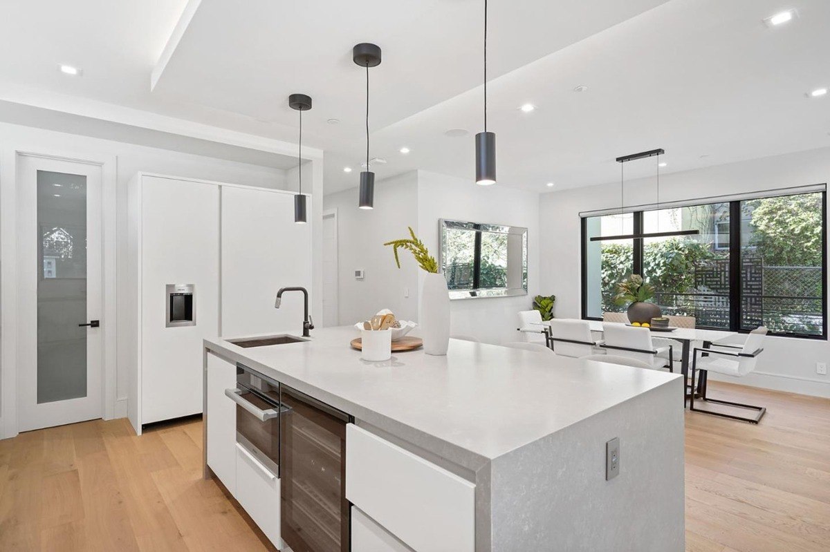 Kitchen and dining view a view showcasing the open kitchen layout adjacent to the dining area with pendant lights and contemporary decor.