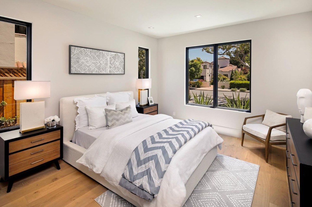 Stylish bedroom a bright bedroom with neutral furnishings, large windows, and modern bedside tables.