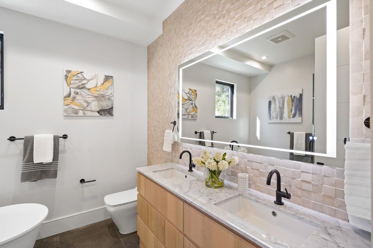 Elegant bathroom vanity a bathroom with a double-sink vanity, illuminated mirror, and modern fixtures.