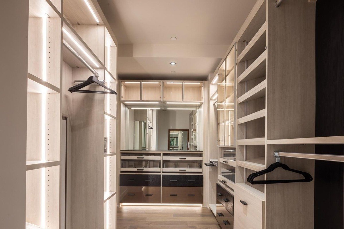 Spacious and well-lit walk-in closet with ample storage space, including shelves, drawers, and hanging rods.