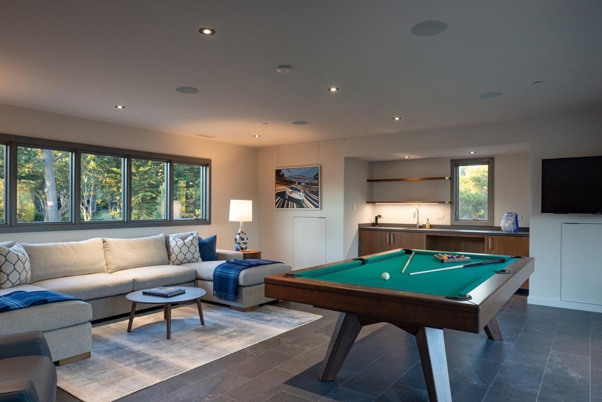 Recreation room with a pool table, a comfortable seating area, and large windows overlooking the scenic surroundings.