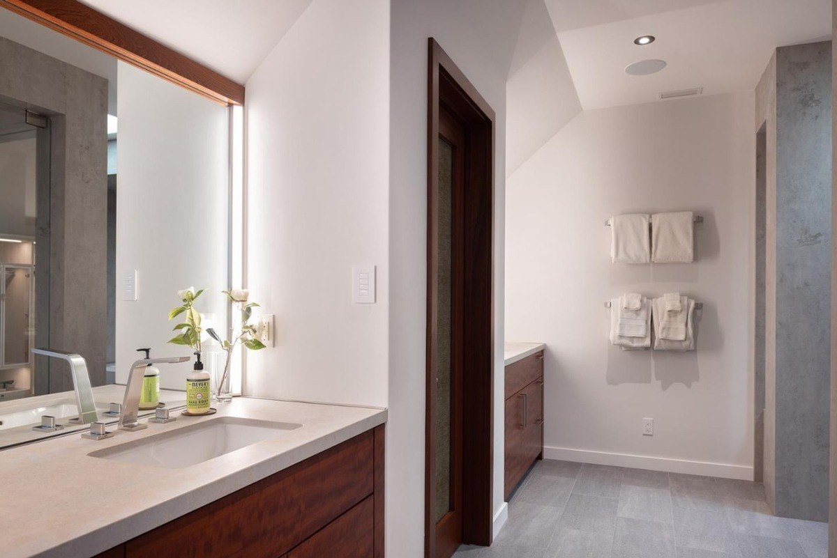 Bathroom with a double vanity, a large mirror, and a sleek design.