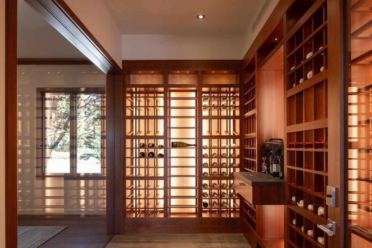 Luxurious wine cellar with custom wood shelving, illuminated racks, and a spacious layout.