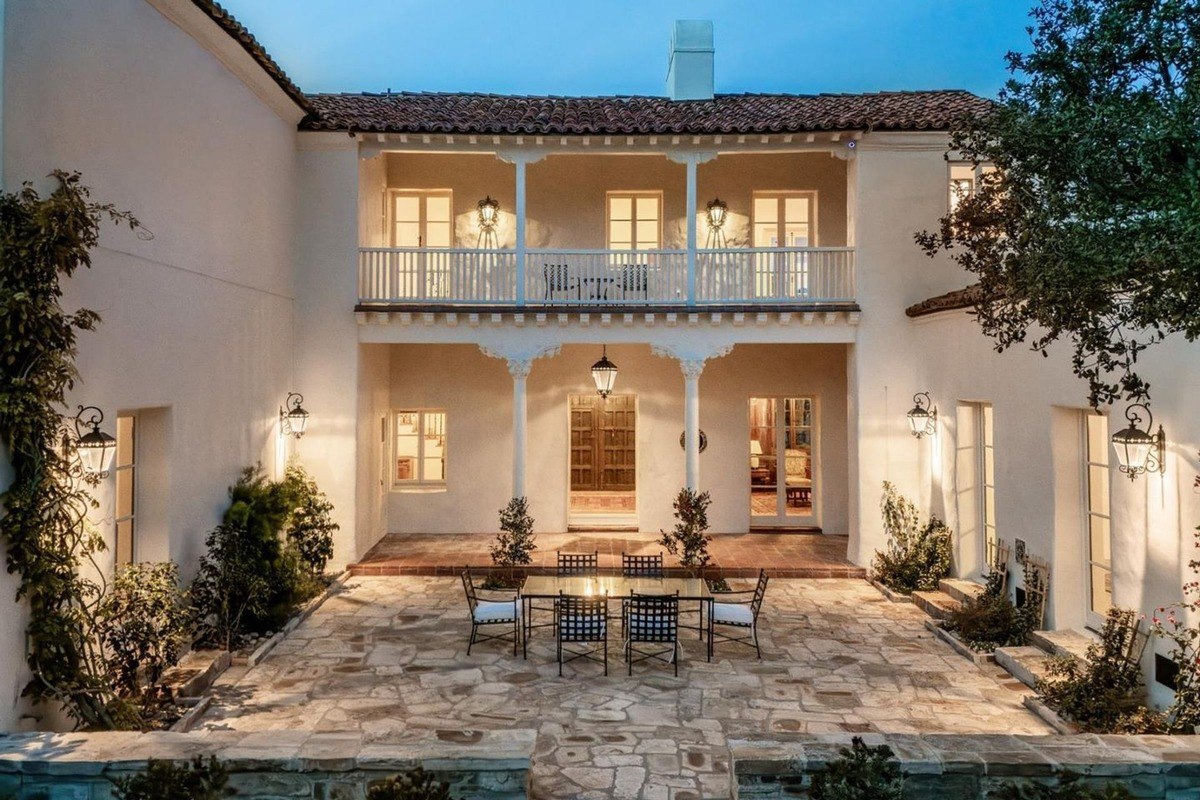 Elegant outdoor dining area arranged on stone tiles beneath soft lighting creates a welcoming ambiance.