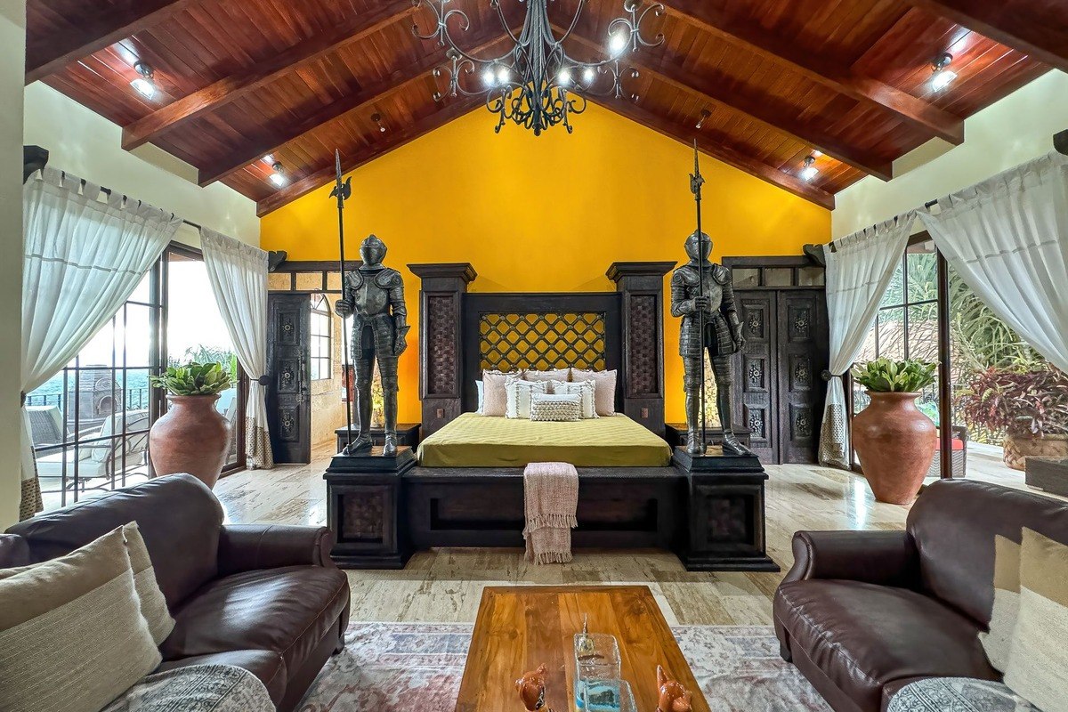 Master bedroom has wood ceiling, leather furniture, and knight statues.