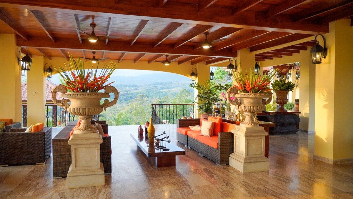 Lounge area has wood ceiling, orange couches, and mountain view.