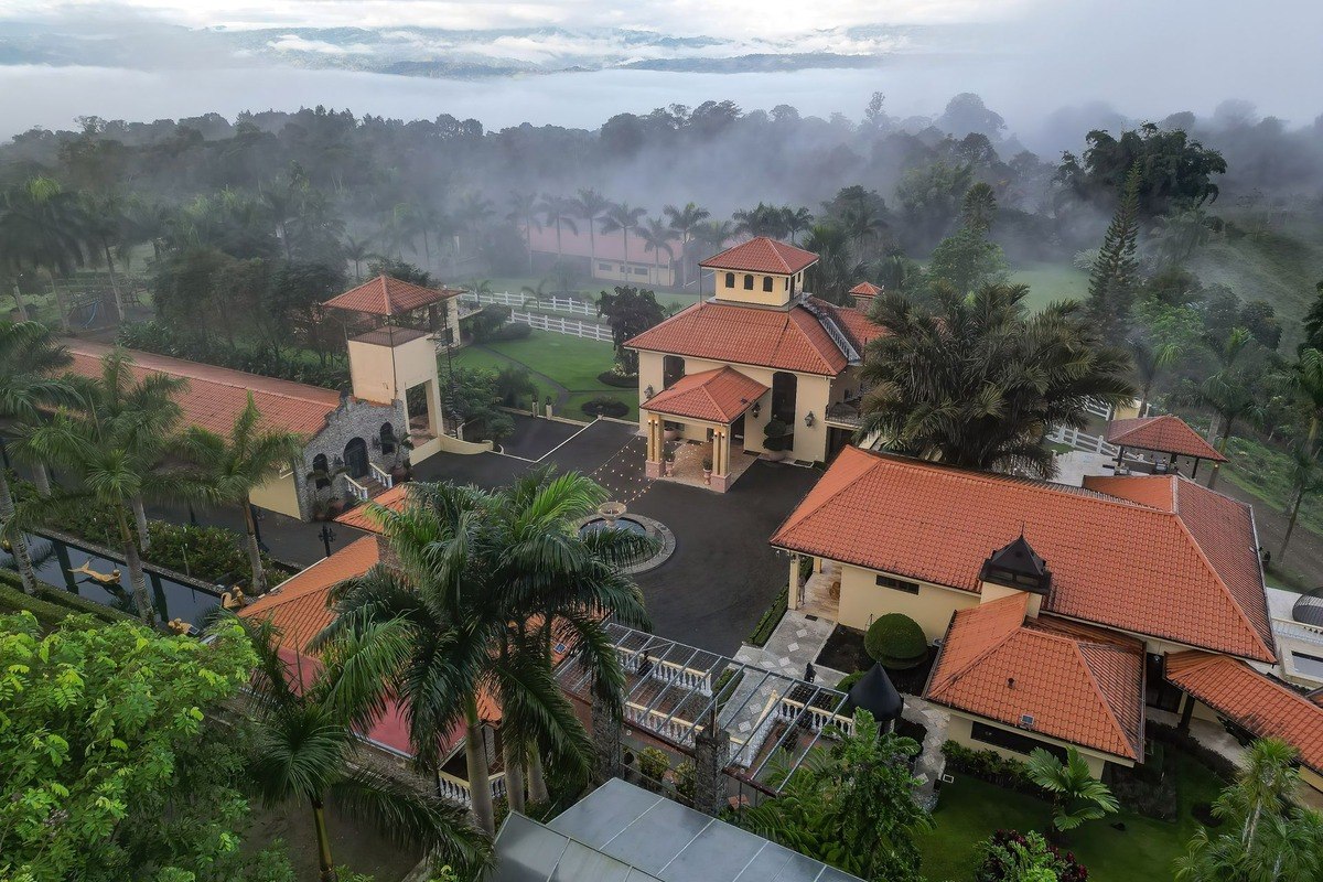 Large estate has multiple buildings, pool, and mountain views.