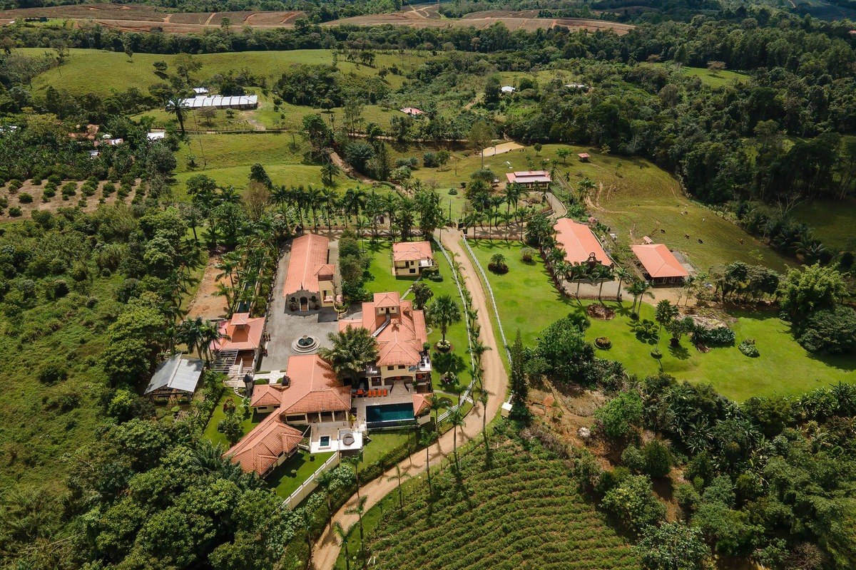 Aerial view shows large estate with multiple buildings and surrounding farmland.