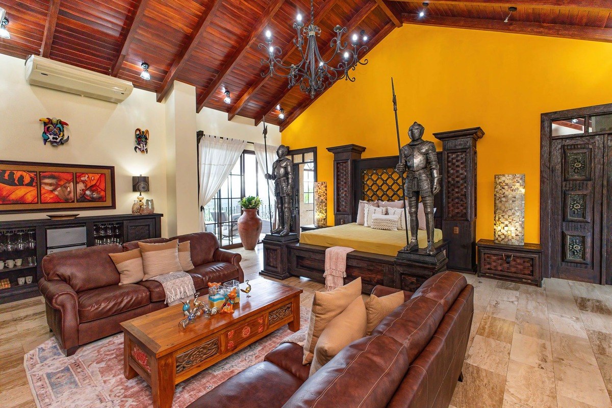 Master bedroom has wood ceiling, leather furniture, and knight statues.