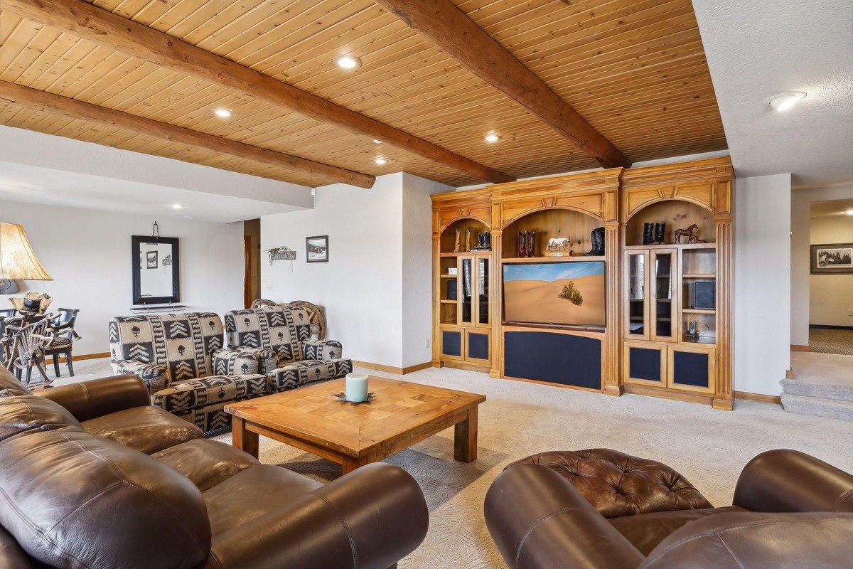 Entertainment section seating area with plush chairs and a built-in wooden entertainment center.