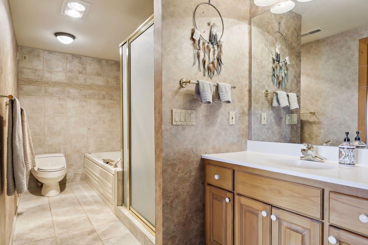 Bathroom with a walk-in shower, soaking tub, and a vanity with a mirror.