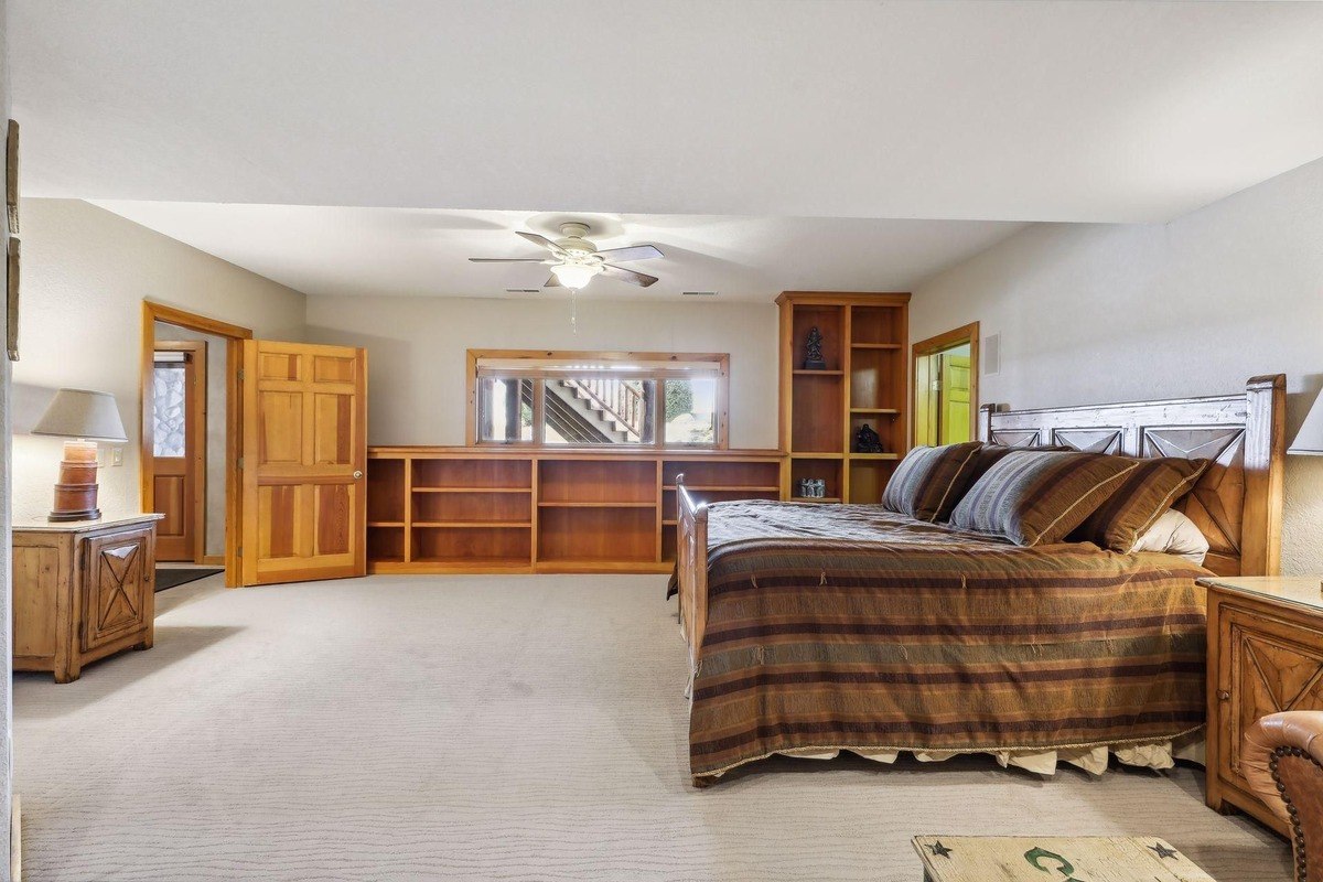 Guest bedroom a guest bedroom with a bed, built-in shelving, and carpet flooring.