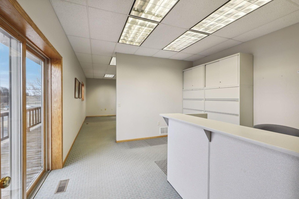 Reception area with a counter, file storage, and access to a deck through sliding doors.