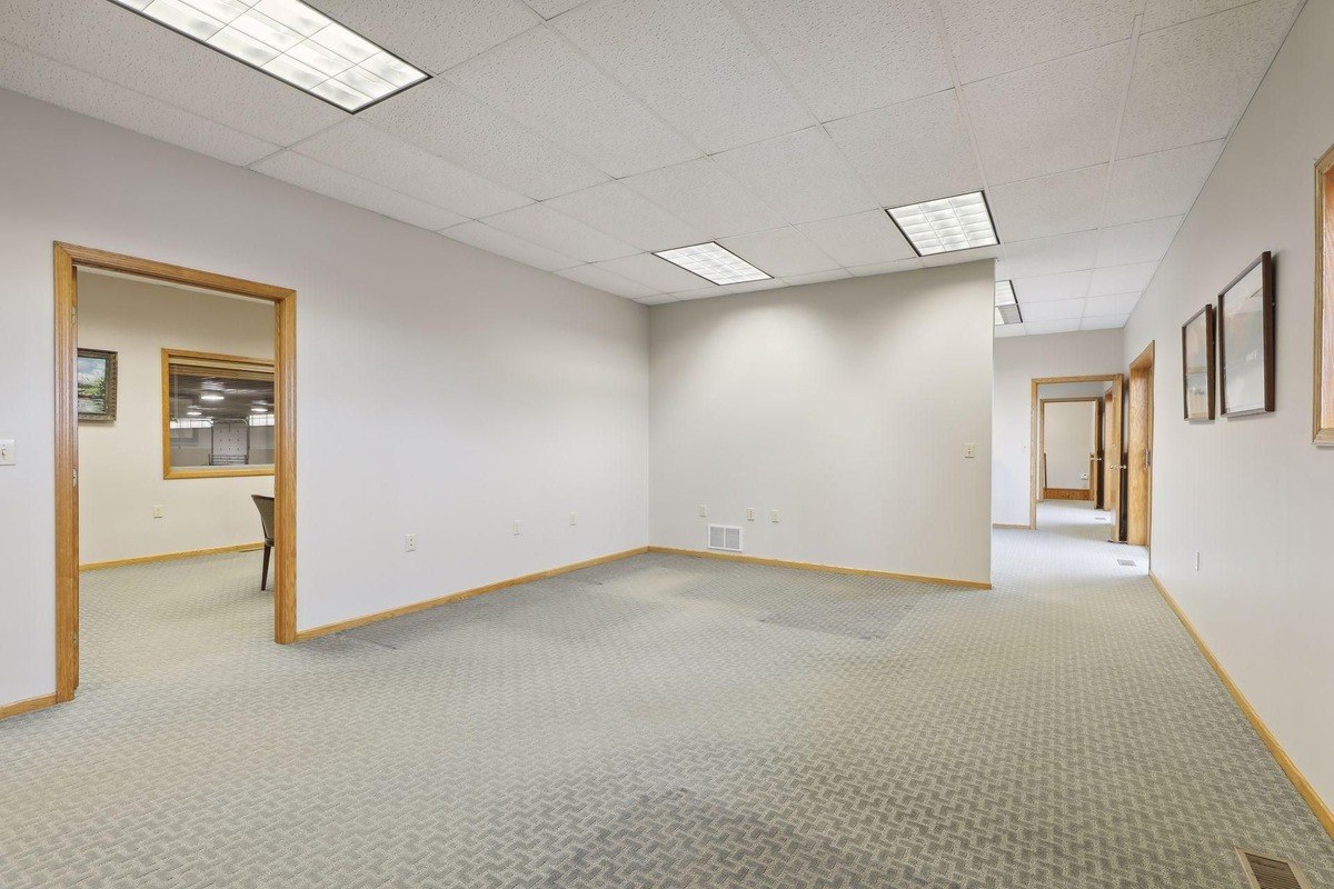 Open office space with neutral walls and carpet, ready for use or customization.