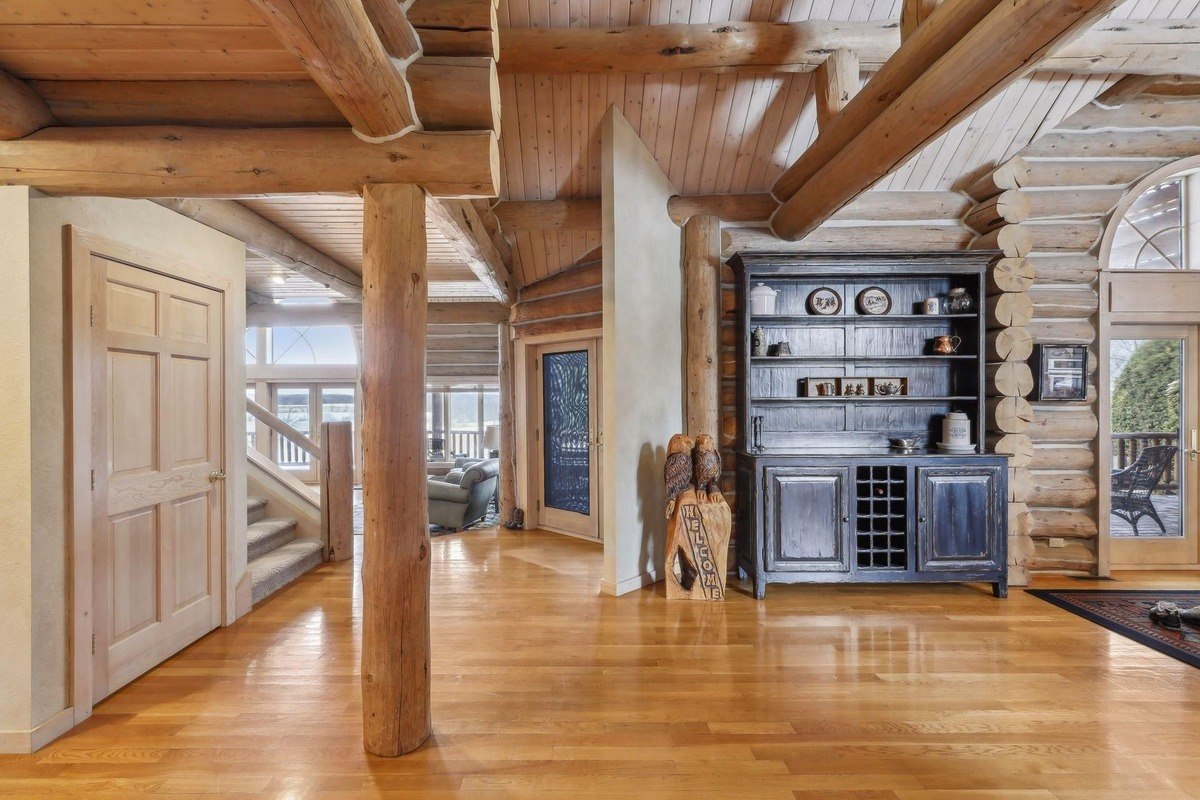 Entryway a log cabin-style foyer with double doors and a mirror-topped console table.