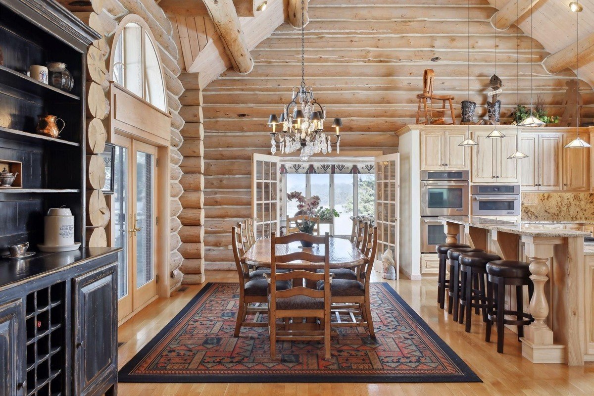 Sunroom cozy sitting area with large windows, natural light, and a decorative fireplace.