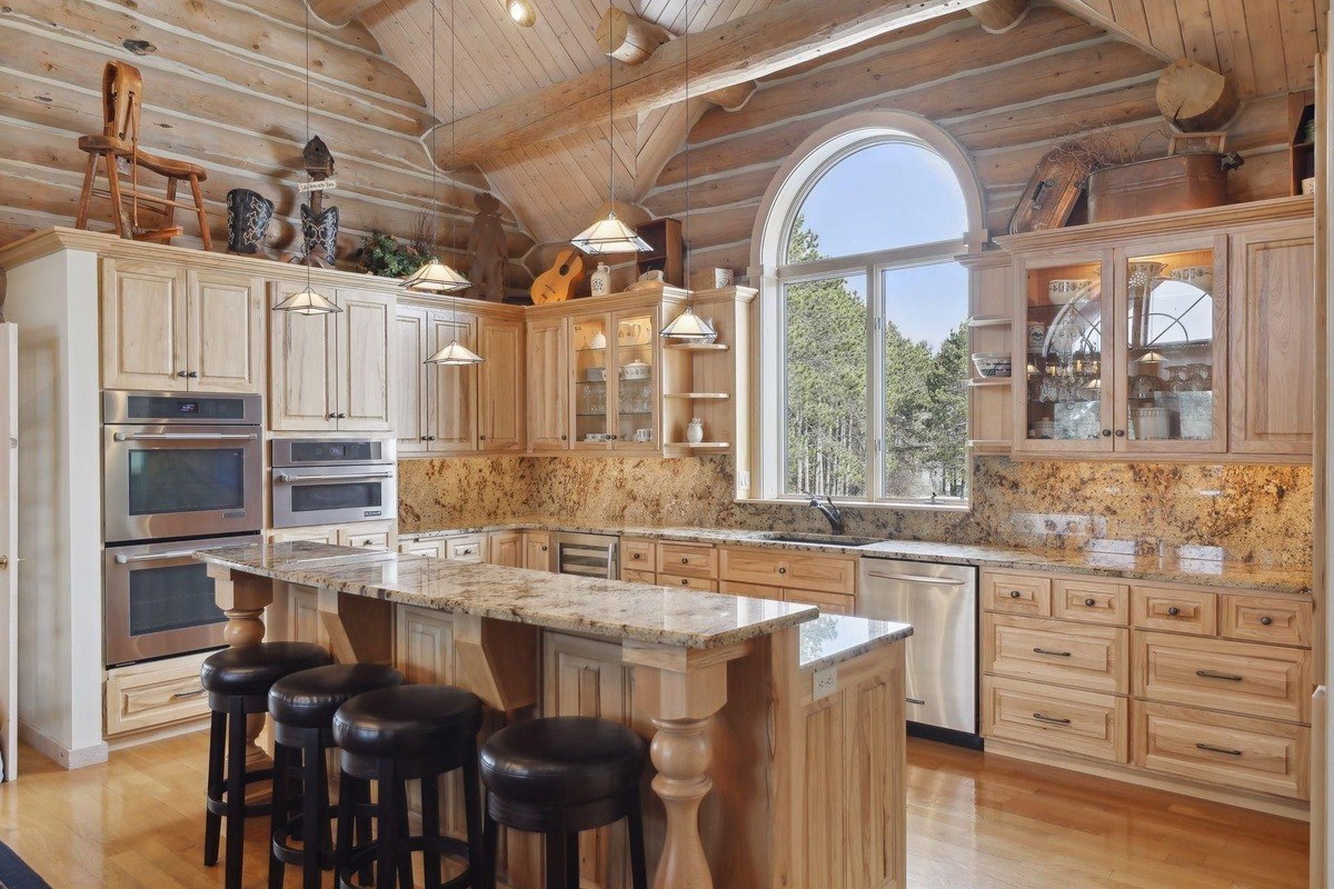 Large kitchen featuring a granite island, wood cabinetry, and stainless-steel appliances.